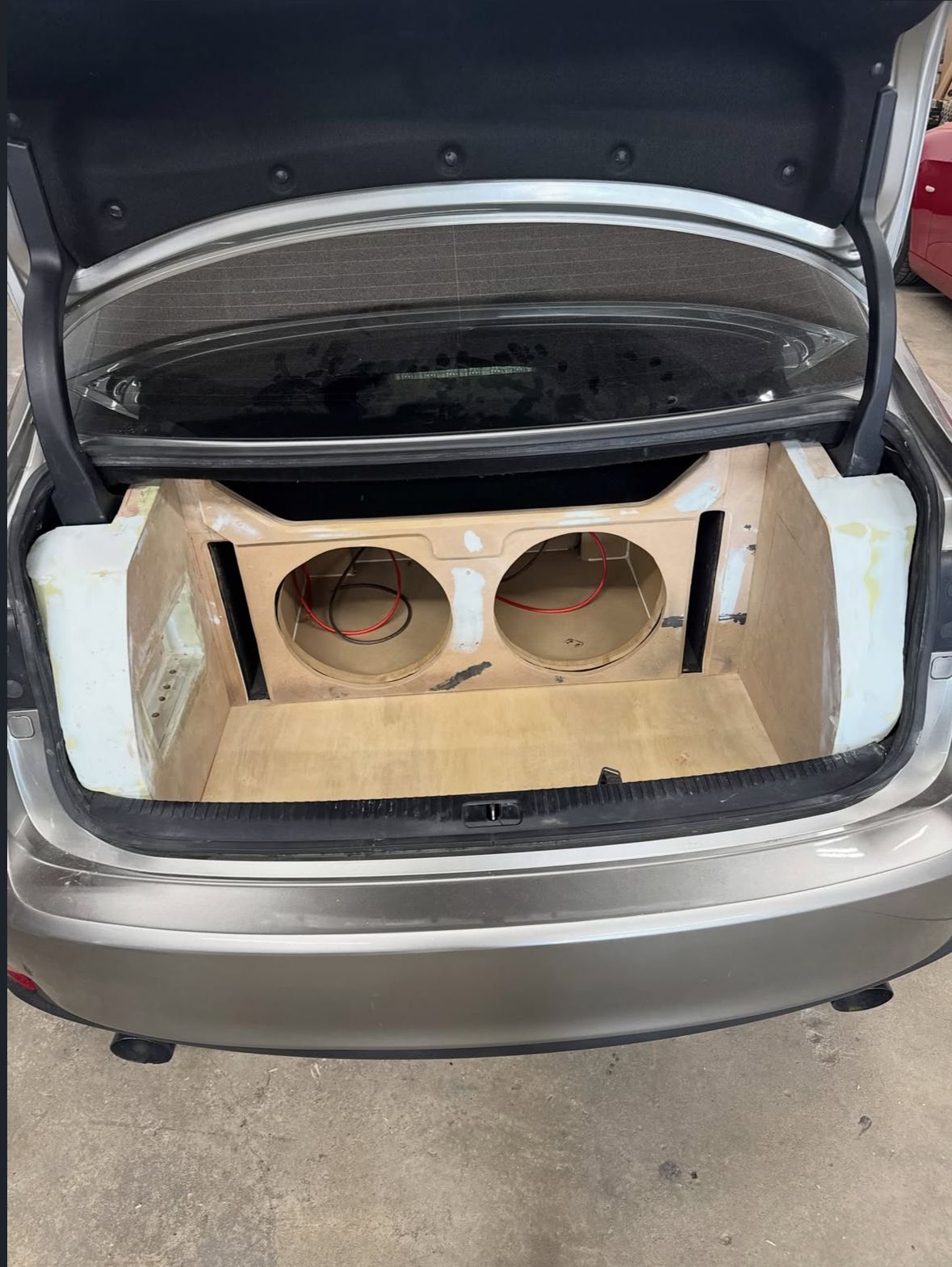 Custom fiberglass and MDF subwoofer enclosure fitted to a trunk