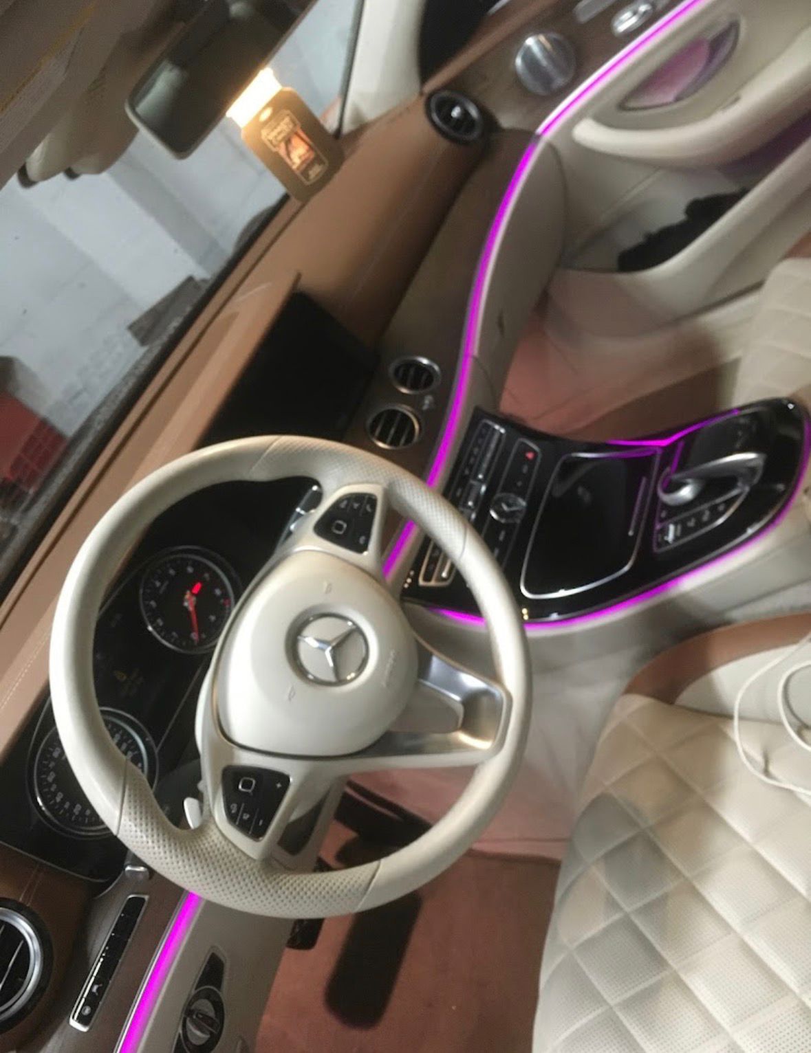 Mercedes interior with custom purple ambient lighting along the dash and console